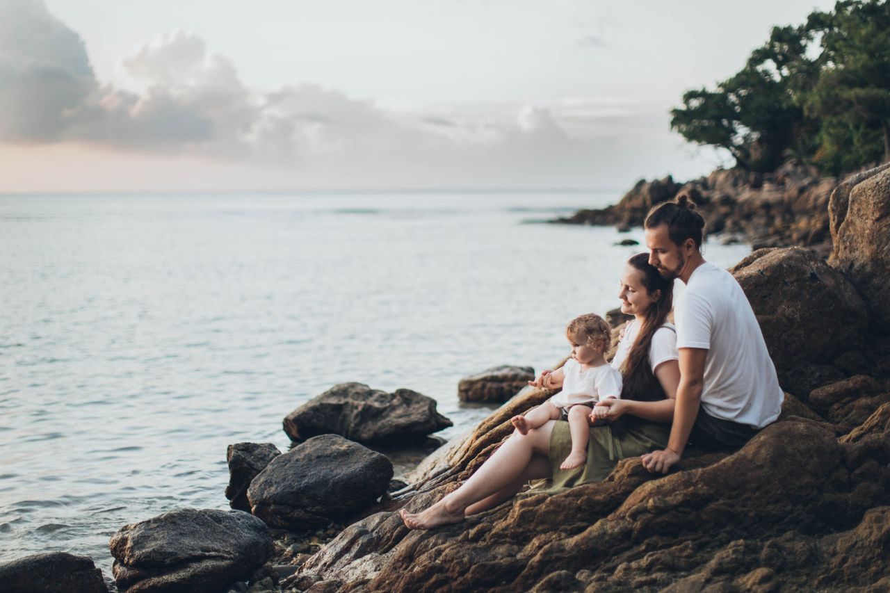 team-01 A serene family moment by the seaside, capturing love and relaxation at sunset.