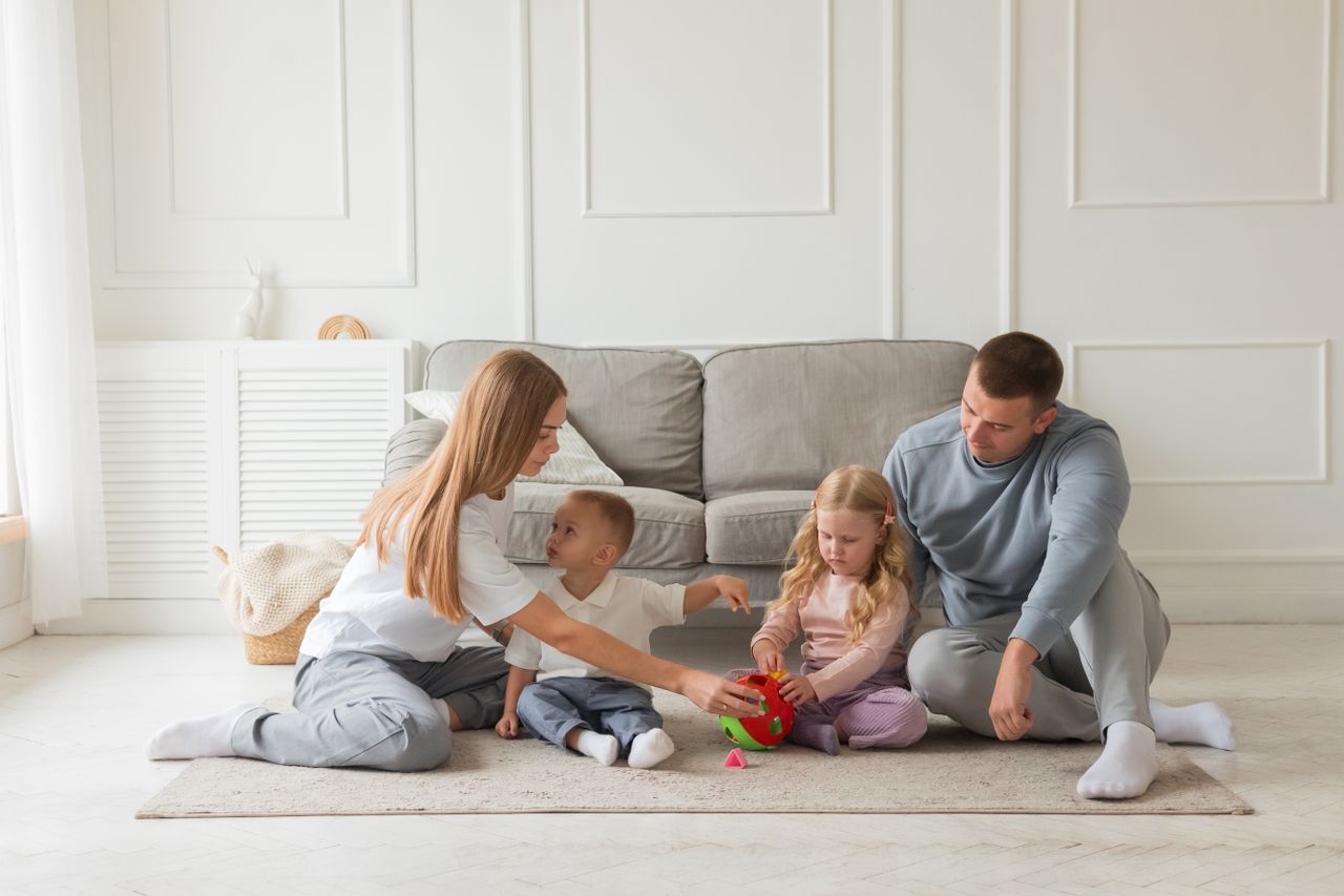who-we-are Family bonding time on the carpet in a cozy living room setting.